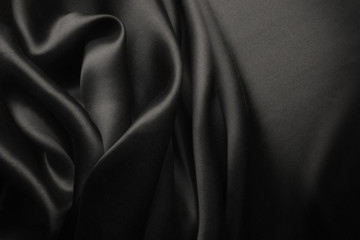 Elegant black satin silk with waves, abstract background