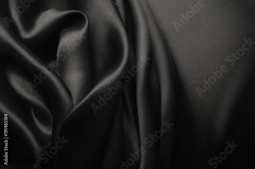 Elegant black satin silk with waves, abstract background