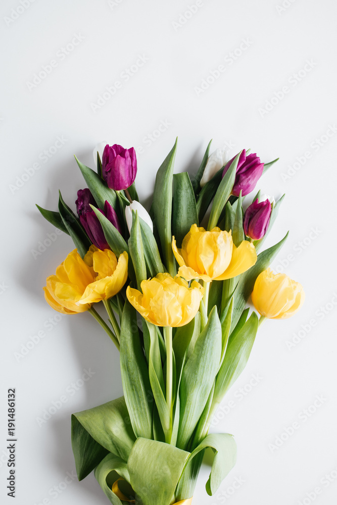 top view of bouquet of purple and yellow tulips on white top view of bouquet of purple and yellow tulips on white