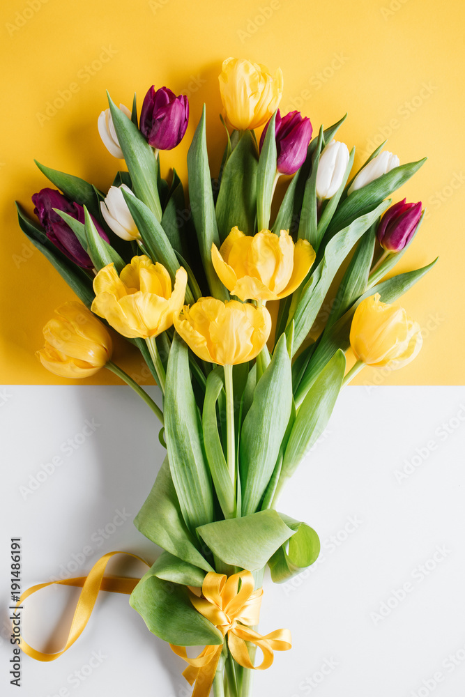 Obraz premium top view of yellow, pink and white tulips with ribbon for international womens day