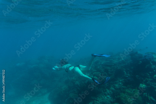 Underwater photo of woman snorkeling and free diving in a clear tropical water at coral reef. Sea underwater.