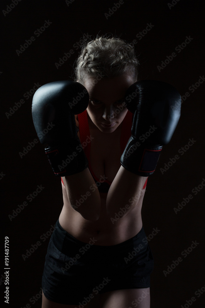 Portrait of a beautiful young woman in boxing gloves. She's a sportswoman.

