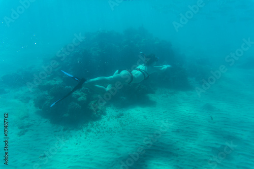 Young woman snorkling under water sea reef and coral. Summer vocation.