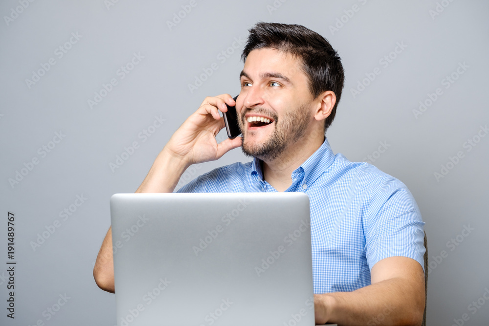 Handsome man dressed in blue shirt and talking on cellphone Handsome man dressed in blue shirt and talking on cellphone