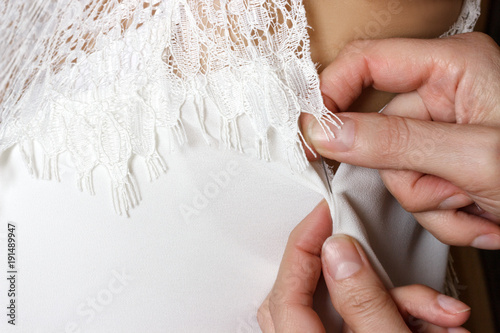 Bridal Gown Fitting. seamstress prepares dress to the fitting