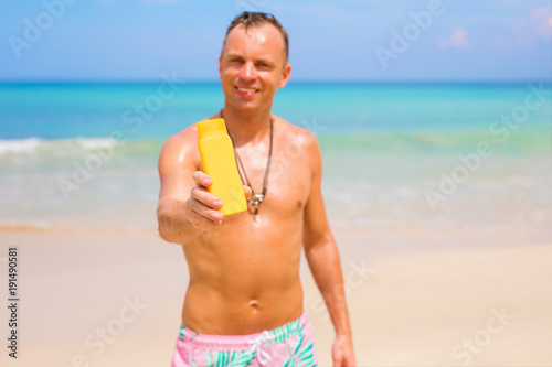 Man holding sunscreen bottle in hand