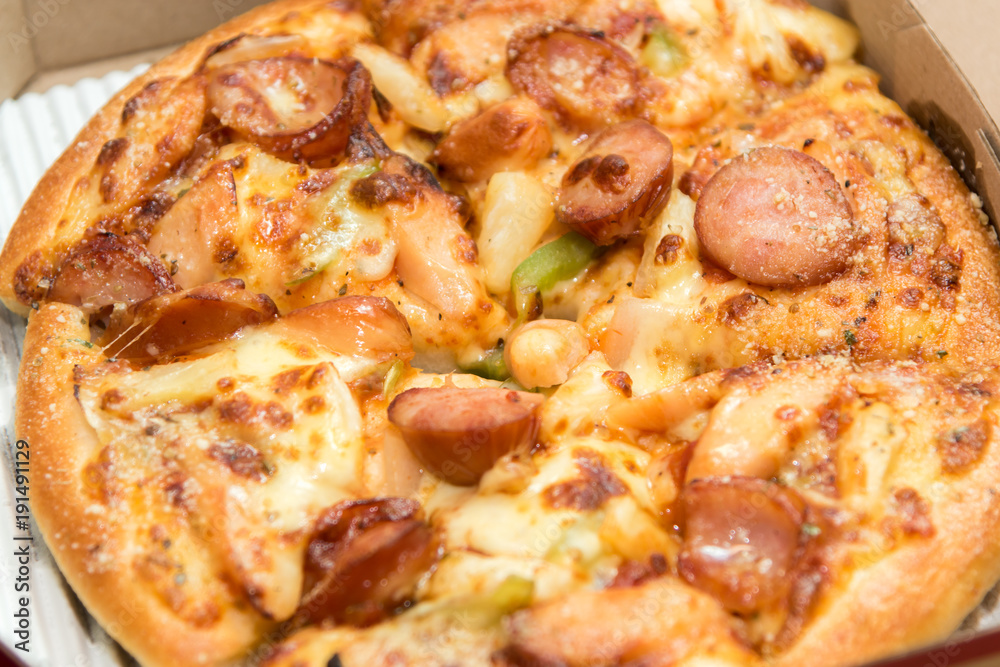 Close up of pizzas with variety of toppings and cheese in cardboard take out boxes with open lid Close up of pizzas with variety of toppings and cheese in cardboard take out boxes with open lid