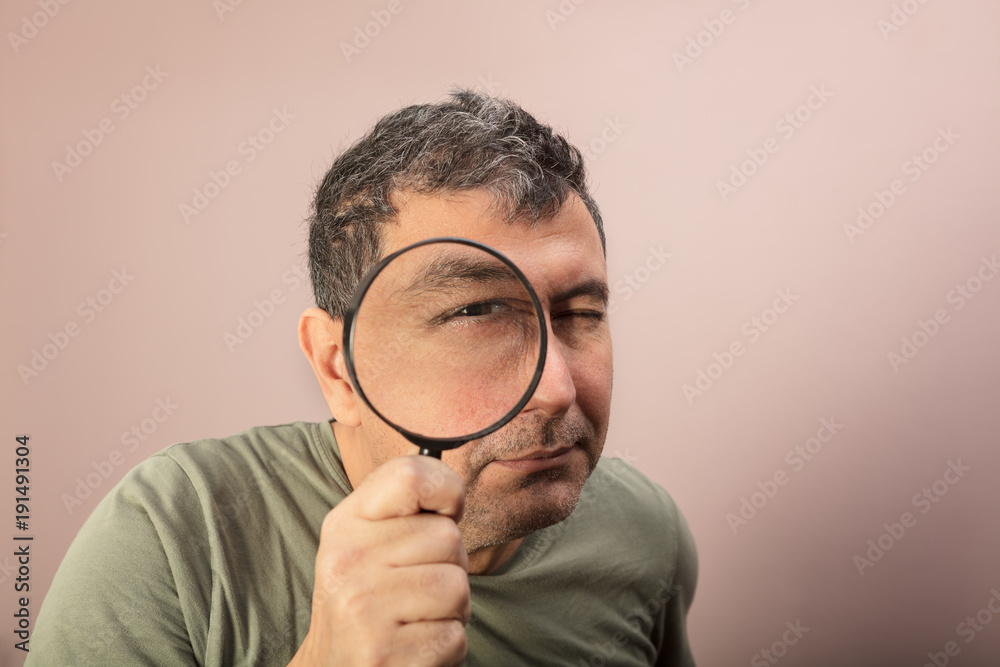Man searching for clues with a magnifying glass Man searching for clues with a magnifying glass