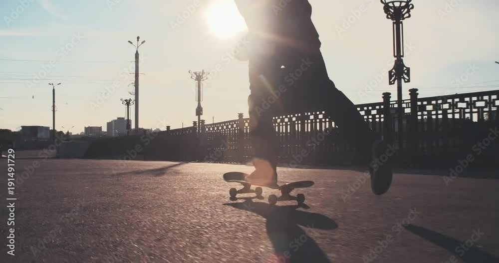 Businessman in suit with briefcase riding skateboard in the street and performing some tricks