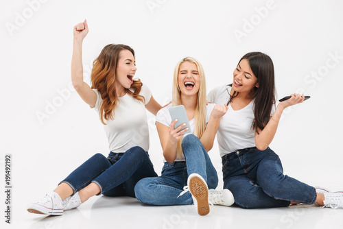Three young excited screaming pretty girls friends chatting