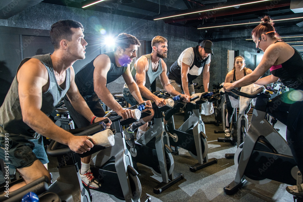 Group of sporty people having spinning class at gym. Stock Photo