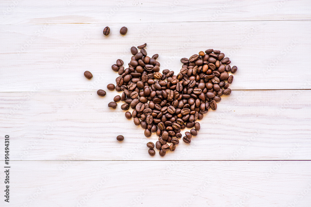 coffee beans heart scatter on white rustic background. top view coffee beans heart scatter on white rustic background. top view