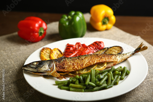 фотографія Healthy and proper food, grilled fish and vegetables with lemon and green beans on a white plate
