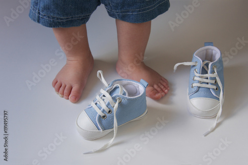 the first baby shoes on the background of the  babies feet 