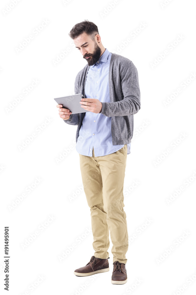 Young adult smart casual businessman holding and watching tablet computer.  Full body length portrait isolated on white studio background. Stock Photo  | Adobe Stock