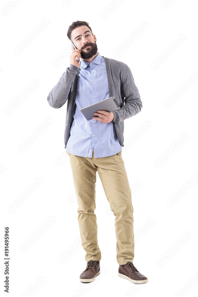 Happy smiling businessman with tablet on the phone looking at camera. Full body length portrait isolated on white studio background. Happy smiling businessman with tablet on the phone looking at camera. Full body length portrait isolated on white studio background.