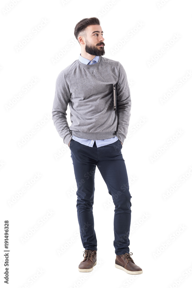 Cool relaxed modern millennial guy with notebook standing and looking away. Full body length portrait isolated on white studio background. Cool relaxed modern millennial guy with notebook standing and looking away. Full body length portrait isolated on white studio background.