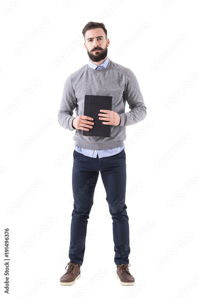 Serious dissatisfied businessman holding documents looking angry at camera. Full body length portrait isolated on white studio background. Serious dissatisfied businessman holding documents looking angry at camera. Full body length portrait isolated on white studio background.