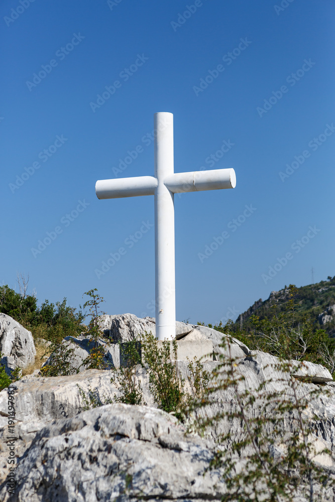White Christian cross symbol in mountains