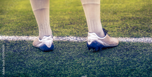Football player is standing in white socks on the football field