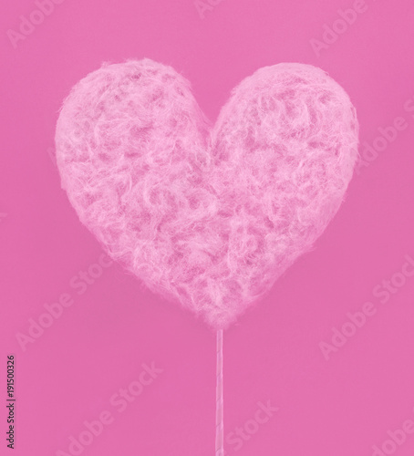 Pink heart made of sweet cotton candy on paper background. Trendy minimal pop art style.