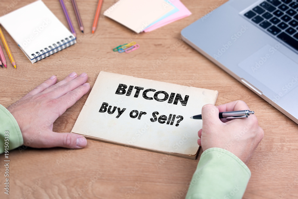 Bitcoin, buy or sell. Office desk with a laptop and stationery. Bitcoin, buy or sell. Office desk with a laptop and stationery.