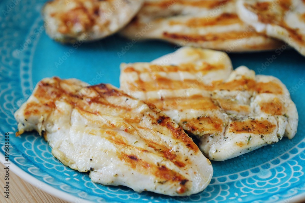Fresh chicken fillet grilled in a blue plate 