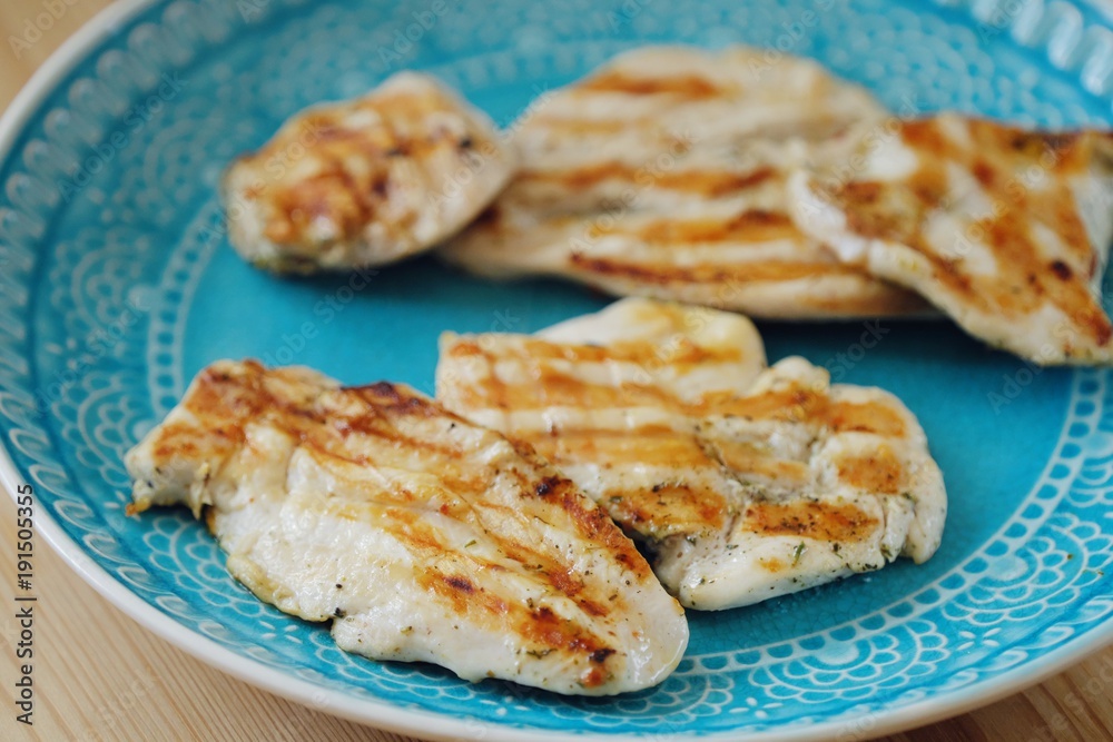 Fresh chicken fillet grilled in a blue plate Fresh chicken fillet grilled in a blue plate