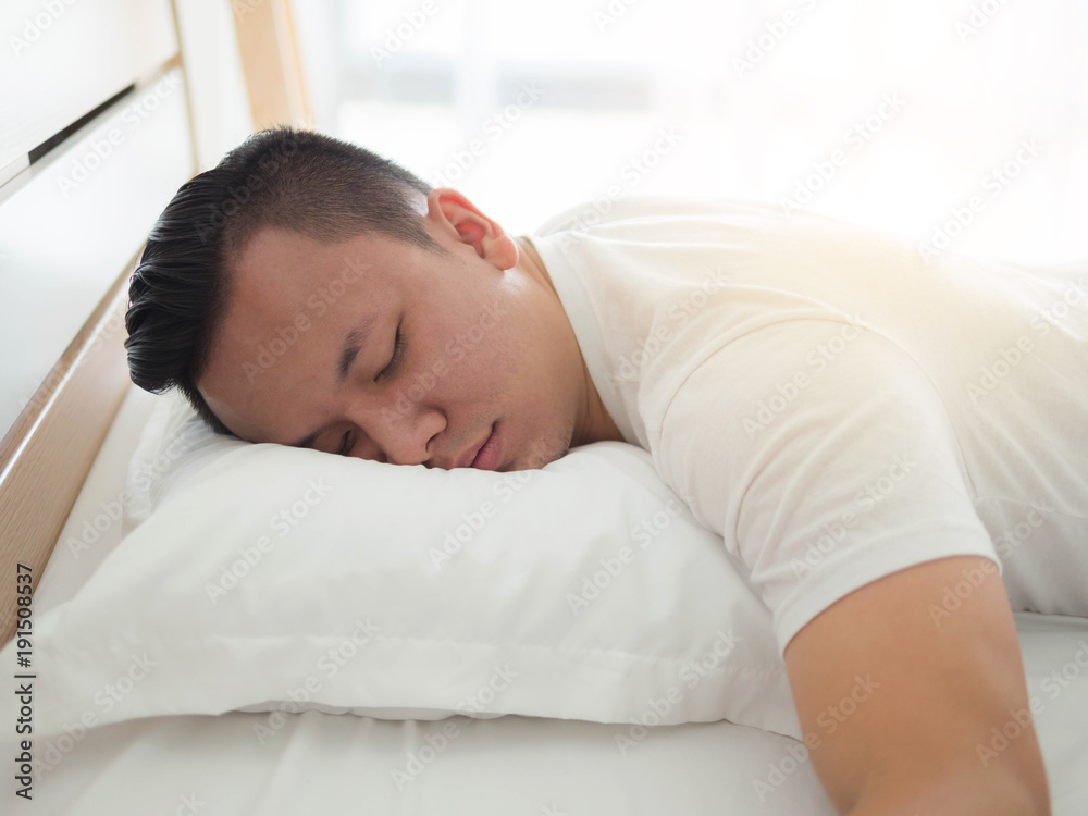 Portrait of a asia man tired sleeping in the bed at home Portrait of a asia man tired sleeping in the bed at home