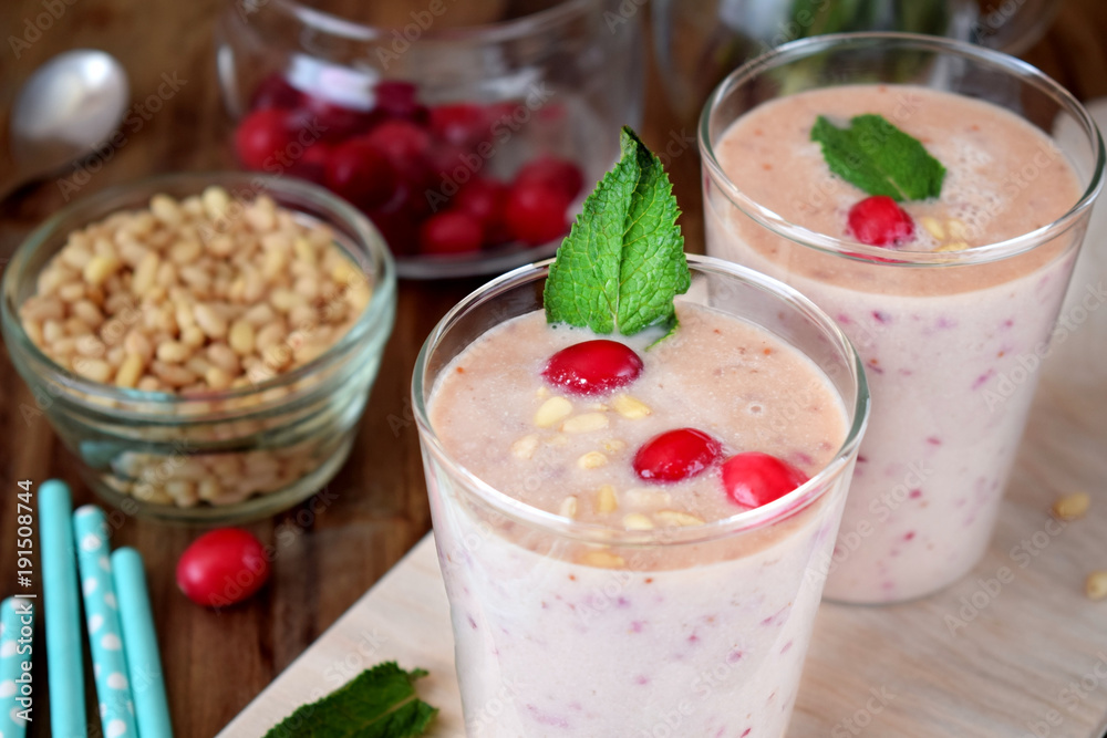 Protein cocktail for healthy nutrition decorated with cranberries, mint and pine kernel nuts in a glass Protein cocktail for healthy nutrition decorated with cranberries, mint and pine kernel nuts in a glass