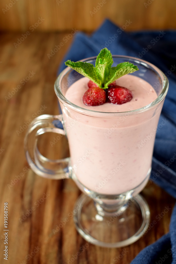 Protein cocktail with strawberries and mint in an Irish mug on wooden background