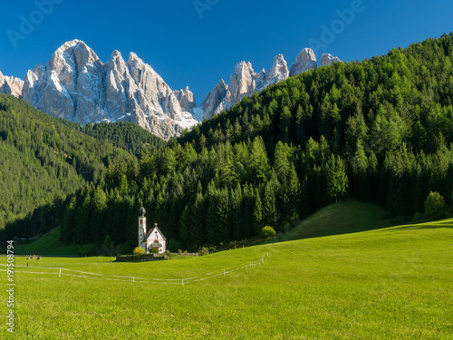 Green grass, blue sky. St Johann Church, Santa Maddalena, Val Di Funes, Dolomites, Italy. September, 2017