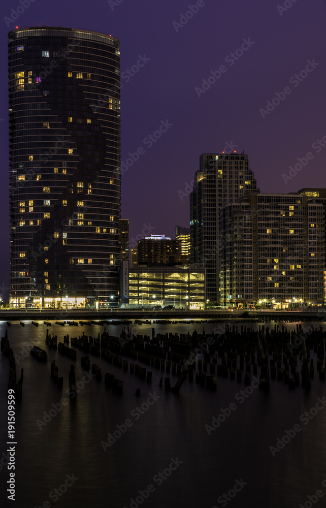 Jersey City, New Jersey skyline at twilight with skyscrapers illuminated over Hudson River