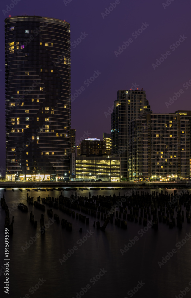 Jersey City, New Jersey skyline at twilight with skyscrapers illuminated over Hudson River Jersey City, New Jersey skyline at twilight with skyscrapers illuminated over Hudson River