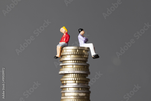 Gender pay equality concept. man and woman on a stack of coins. photo