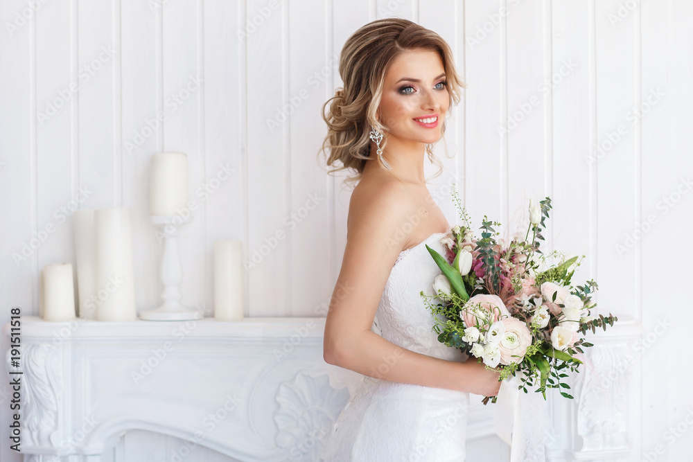 Portrait of a beautiful bride with a wedding bouquet. Blonde girl with curly hair and fashion makeup.