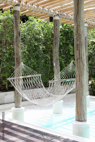 White hammock hanging over the pool in the resort.