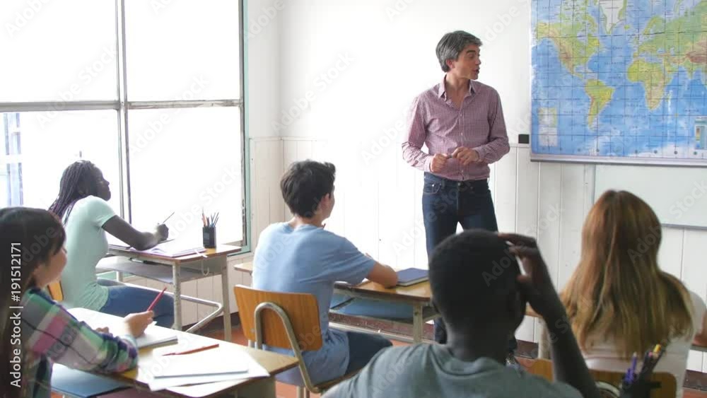 Teacher making lesson in a multi race teens classroom Teacher making lesson in a multi race teens classroom