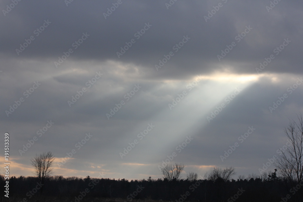 Sun rays streaming though clouds on a cloudy, overcast morning.
Sun rays streaming though clouds on a cloudy, overcast morning.