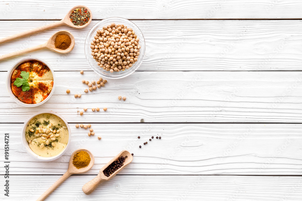 Cook chickpeas. Make hummus. Bowls with grains and ready meal near spices on white wooden background top view copy space Cook chickpeas. Make hummus. Bowls with grains and ready meal near spices on white wooden background top view copy space