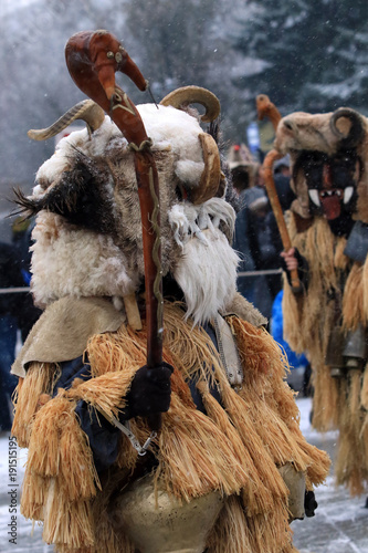 Breznik, Bulgaria - January 20, 2018: Unidentified people with traditional Kukeri costume are seen at the Festival of the Masquerade Games Surova in Breznik, Bulgaria