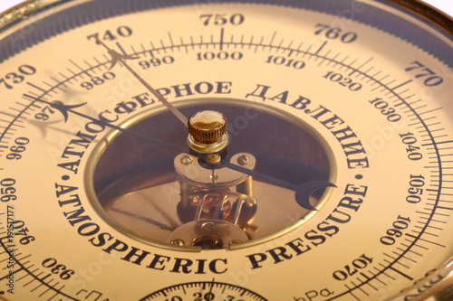 Old yellow-brown aneroid barometer in wooden body close-up