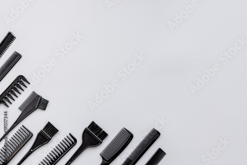 Hairdressing tools. Pattern with various combs and brushes on grey background top view copy space