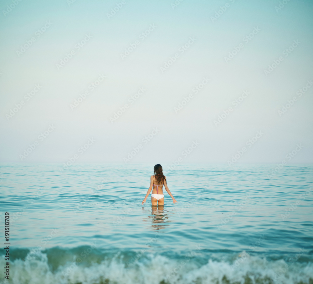 beautiful sexual young woman stands on the beach against the sea and sky. happy woman enjoying summer vacation beautiful sexual young woman stands on the beach against the sea and sky. happy woman enjoying summer vacation