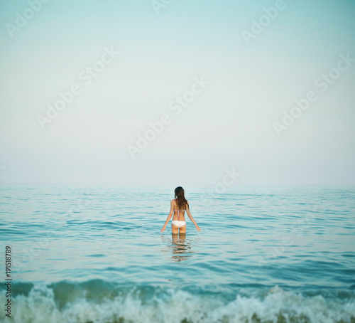 beautiful sexual young woman stands on the beach against the sea and sky. happy woman enjoying summer vacation