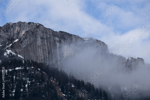 Vertical stone wall engulfed in clouds in the mountains of Austria