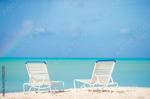White lounge chairs on a beautiful tropical beach at Maldives