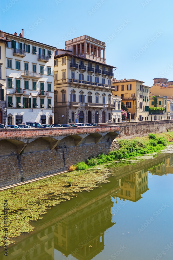 Buildings on the banks of the Arno River in the city of Florence. Italian architecture. Urban landscape in Italy. Reflections on water. June 2017.