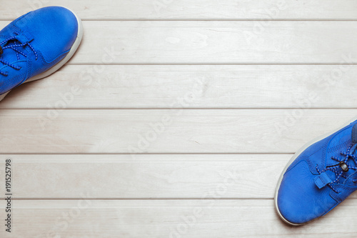 pair of blue sneakers on wooden background flat view