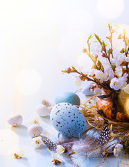 Happy Easter;  Easter eggs and sprig flowers on blue table background